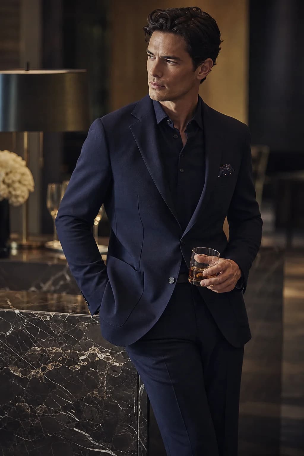 A man in a perfectly fitted black dinner jacket at a formal evening event